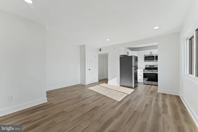 a view of an empty room with closet and a window