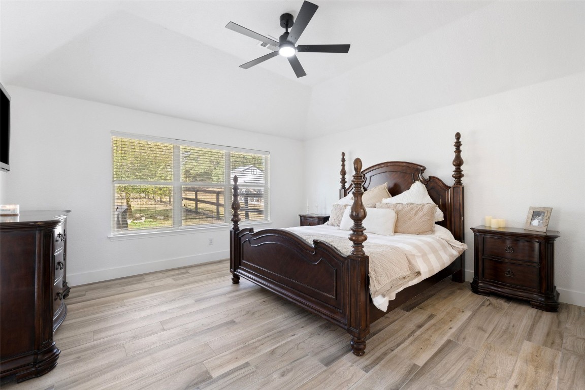 213 Beauchamp Road Dripping Springs, TX 78620 - Photo 16 of 40 a bedroom with a bed and wooden floor