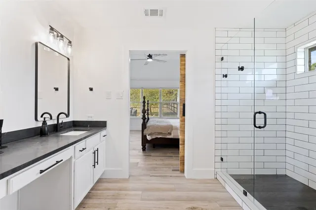 a bathroom with a granite countertop sink a toilet and shower