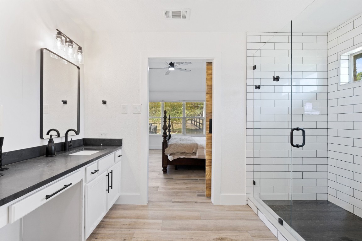 213 Beauchamp Road Dripping Springs, TX 78620 - Photo 18 of 40 a bathroom with a granite countertop sink a toilet and shower