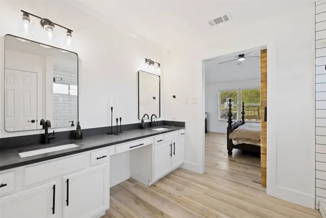a en suite bathroom with a granite countertop sink and a mirror
