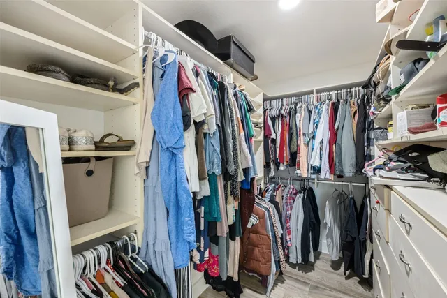 a view of walk in closet with clothes