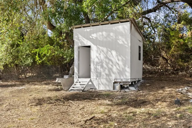 a view of a house with backyard and trees