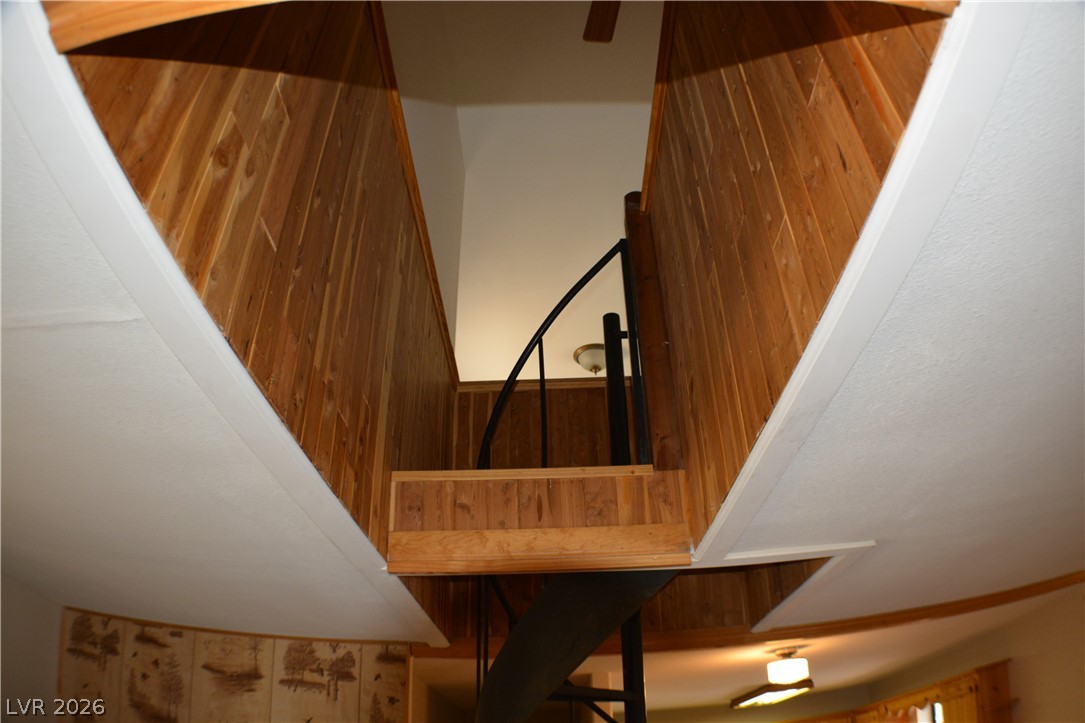 1321 Trout Canyon Road Las Vegas, NV 89124 - Photo 38 of 50 A striking spiral staircase with rich wood paneling provides a dramatic architectural centerpiece.