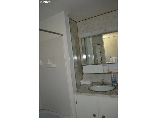 a bathroom with a granite countertop sink and a mirror
