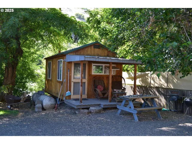 a view of a chair and table in backyard of the house
