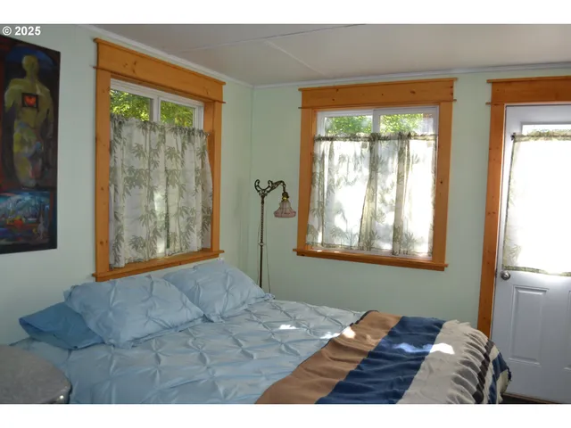 a bed sitting in a bedroom next to a window
