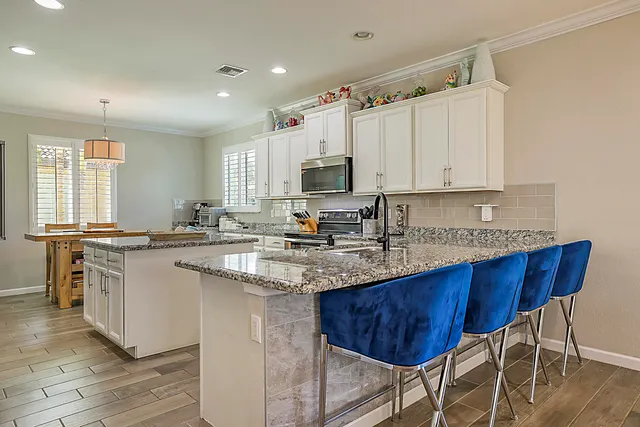 a kitchen with stainless steel appliances granite countertop a sink stove and cabinets