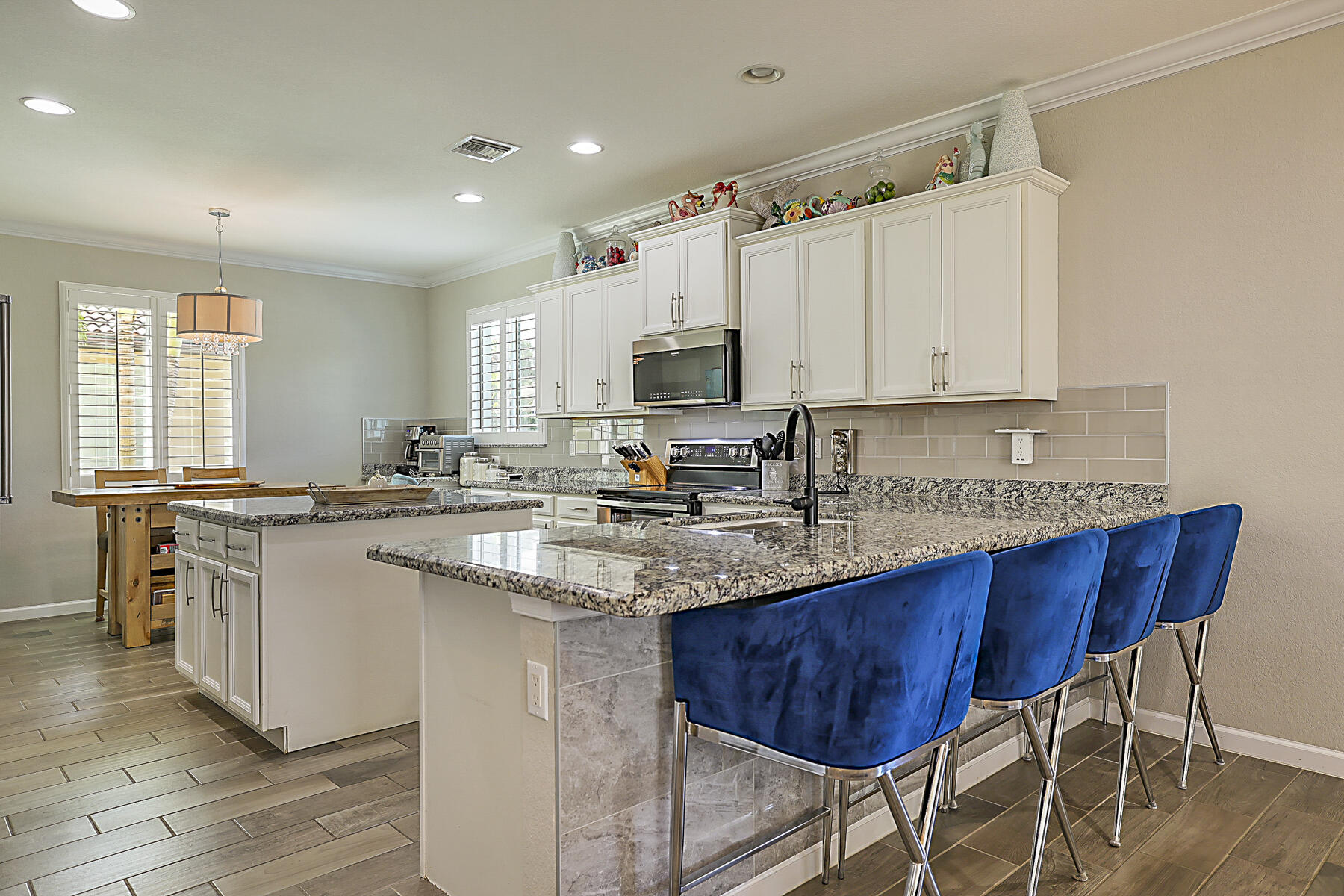 7131 Limestone Cay Road Limestone Creek, FL 33458 - Photo 14 of 65 a kitchen with stainless steel appliances granite countertop a table chairs sink refrigerator and microwave