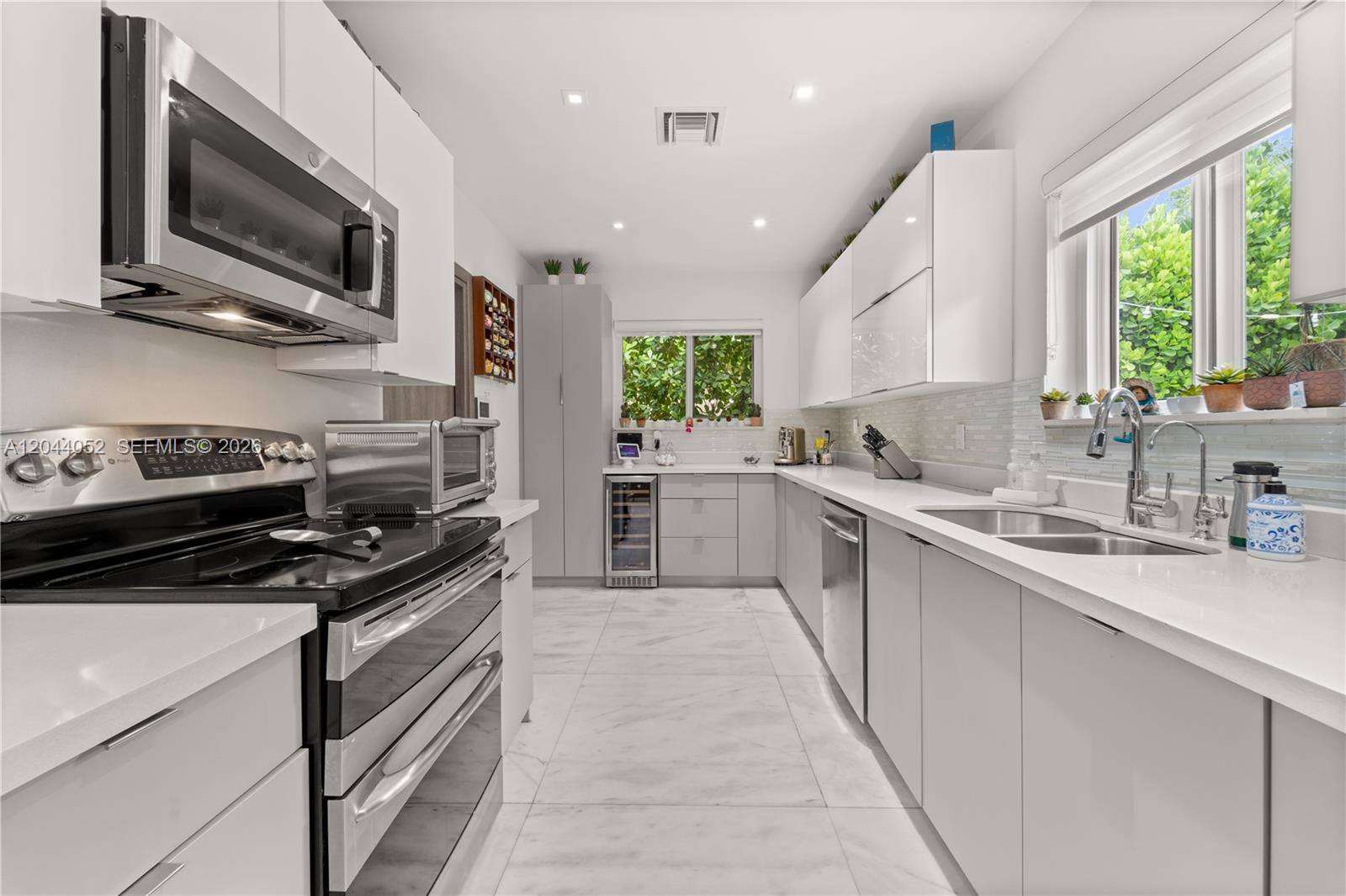721 Bird Road Coral Gables, FL 33146 - Photo 8 of 24 a kitchen with stainless steel appliances a stove sink microwave and cabinets