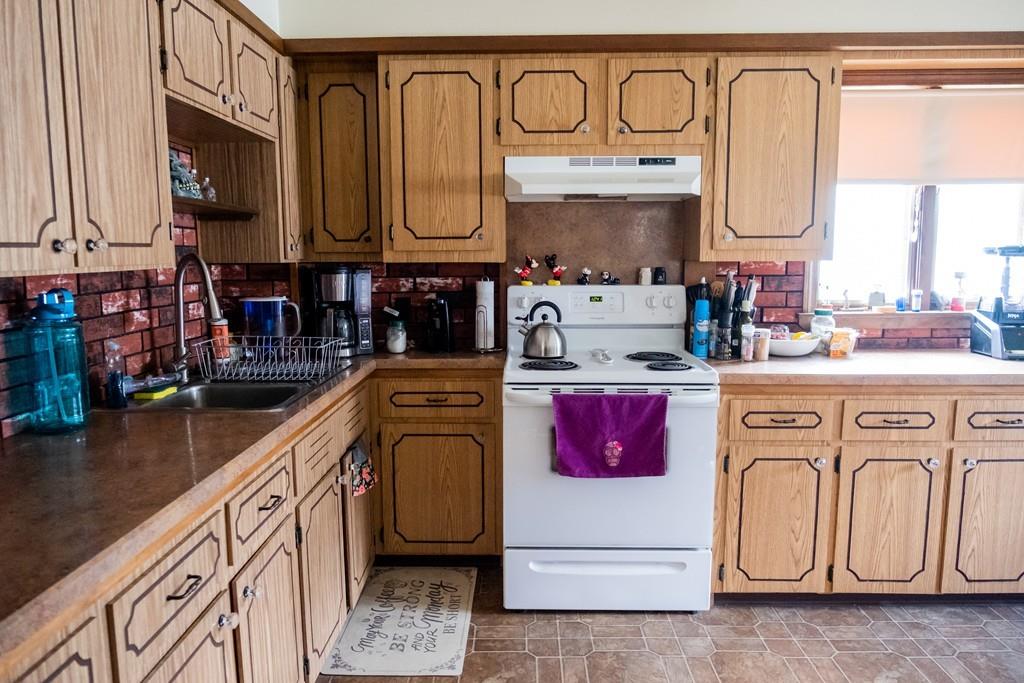 97 Stevens Street Fall River, MA 02721 - Photo 16 of 20 a kitchen with stainless steel appliances granite countertop a sink a stove and cabinets