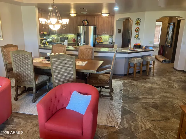 a living room with furniture a large window and kitchen view