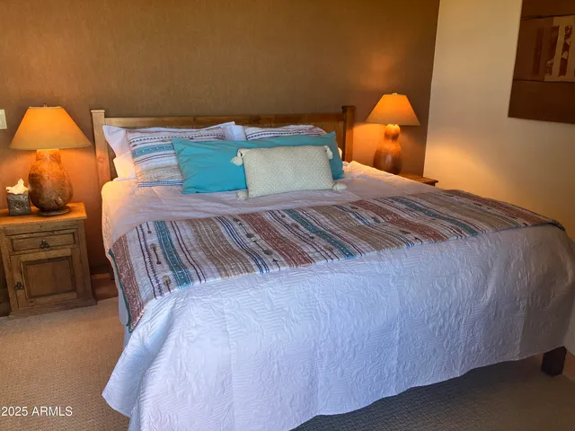 a bedroom with a bed and teddy bear on bed