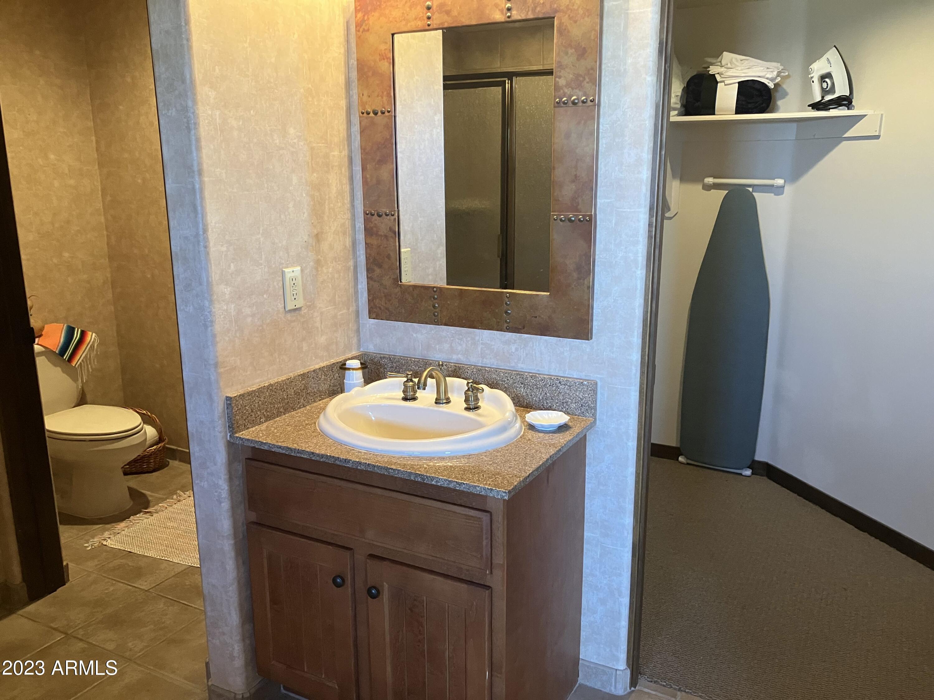 36601 North Mule Train Road, Unit 12C Carefree, AZ 85377 - Photo 29 of 42 a bathroom with a sink a toilet and a mirror