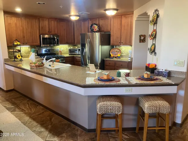 a kitchen with stainless steel appliances granite countertop a sink refrigerator and microwave