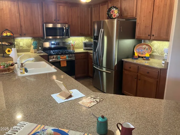 a kitchen with stainless steel appliances granite countertop a refrigerator stove and microwave