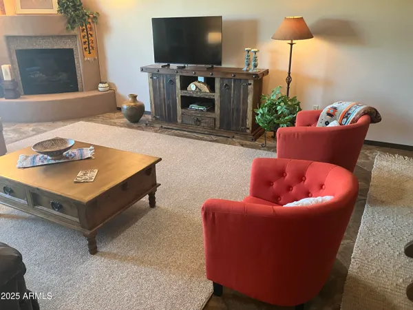 a living room with furniture a flat screen tv and a fireplace