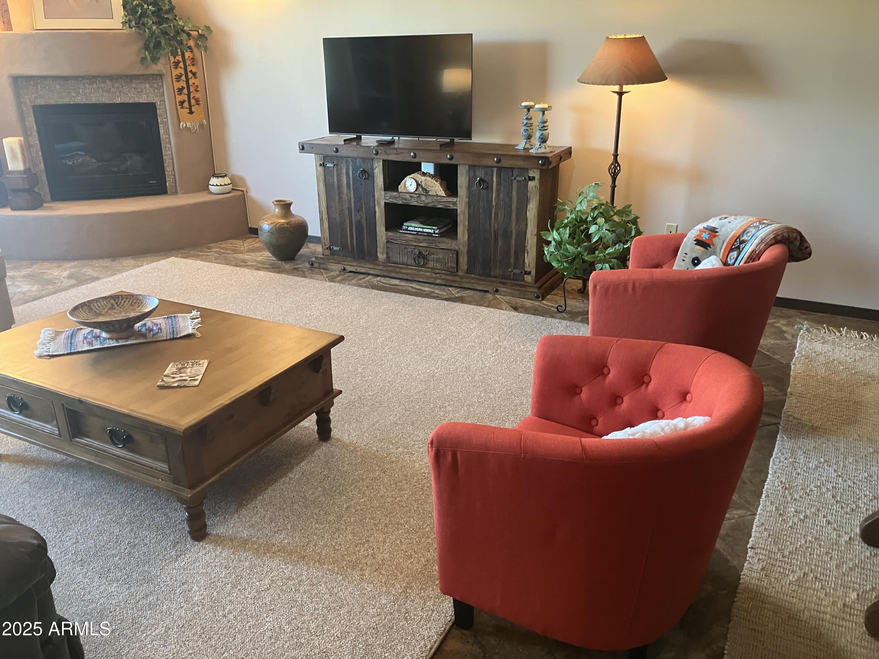 36601 North Mule Train Road, Unit 12C Carefree, AZ 85377 - Photo 9 of 42 a living room with furniture a flat screen tv and a fireplace