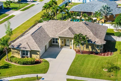 a aerial view of a house with a yard table and chairs
