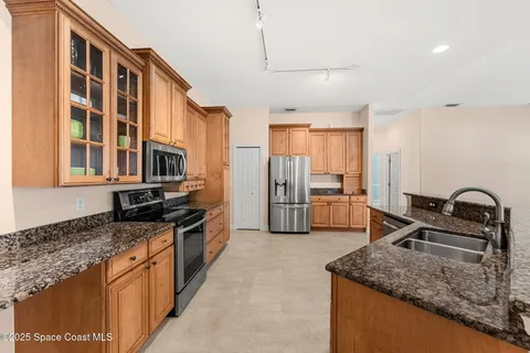 a kitchen with stainless steel appliances granite countertop a sink stove and refrigerator
