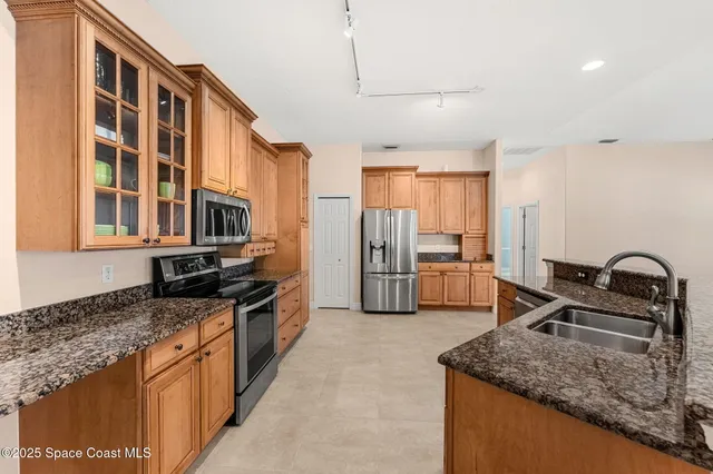a kitchen with stainless steel appliances granite countertop a sink stove and refrigerator