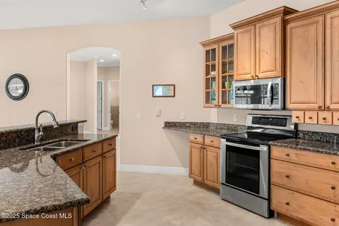 a kitchen with stainless steel appliances granite countertop a stove a sink and a microwave