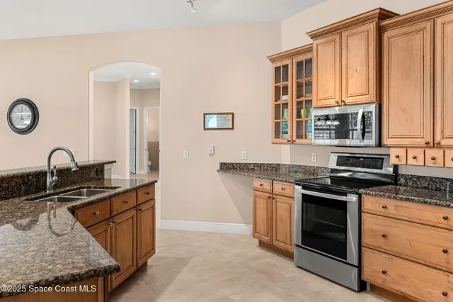 a kitchen with stainless steel appliances granite countertop a stove a sink and a microwave