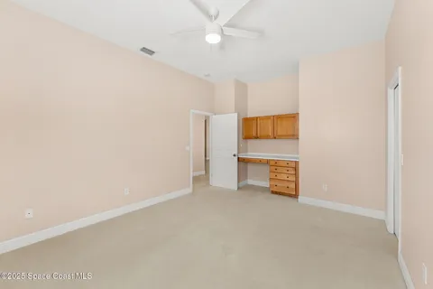 an empty room with a ceiling fan and closet
