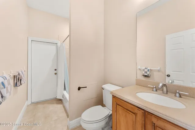 a bathroom with a granite countertop sink a toilet and a mirror