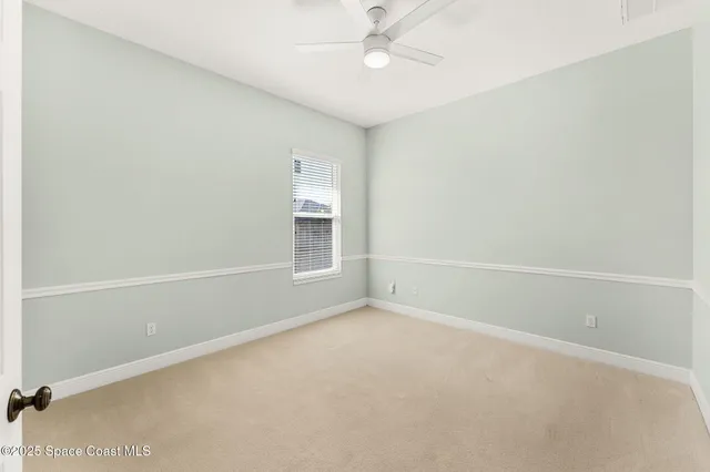 an empty room with a ceiling fan and a window