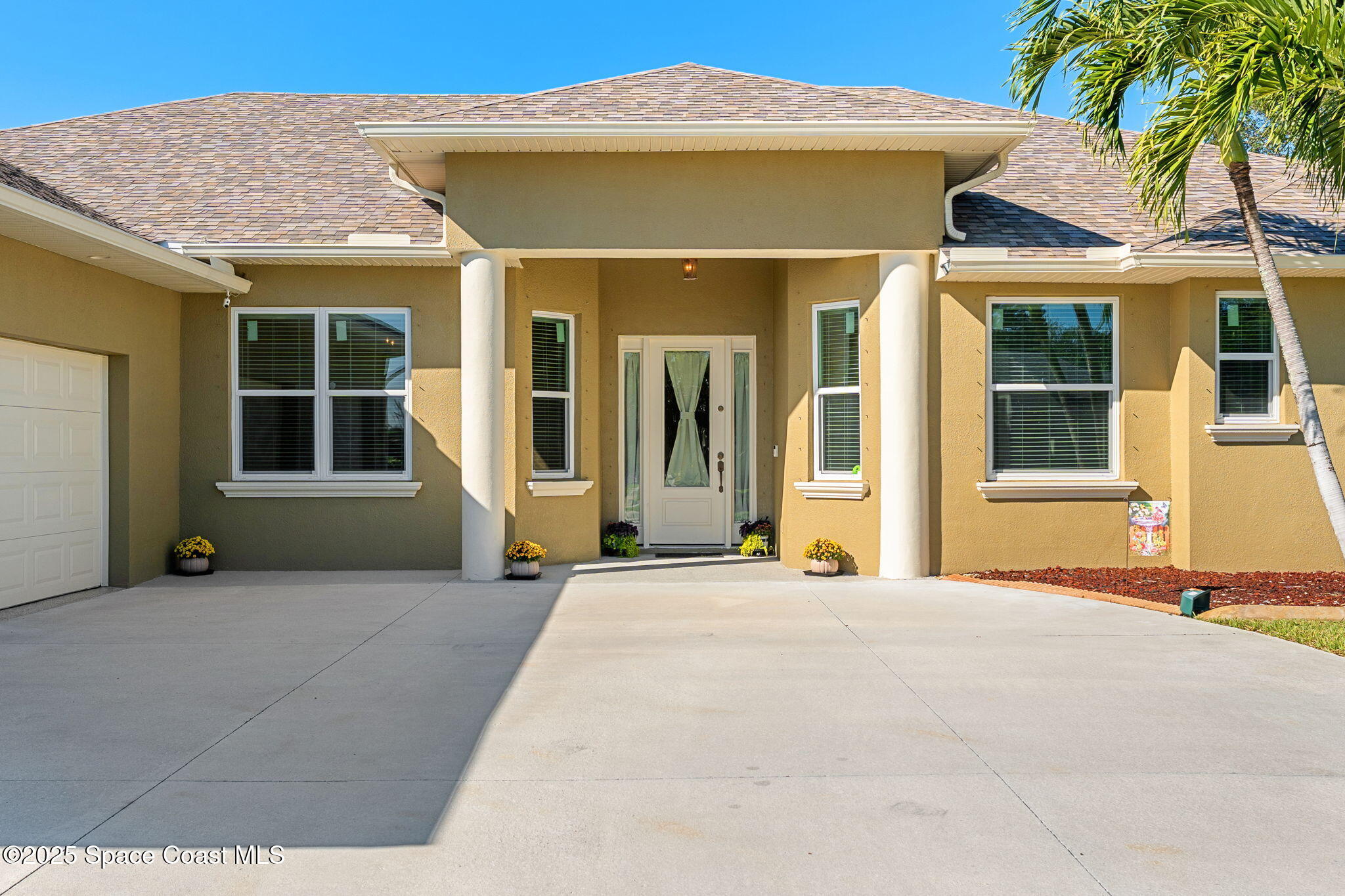 1239 Guy Island Drive Merritt Island, FL 32952 - Photo 3 of 42 a front view of a house with a garden