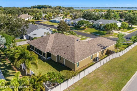 an aerial view of a house with a garden and lake view