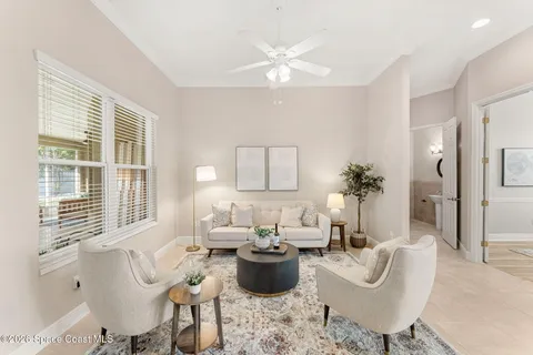a living room with furniture and white kitchen