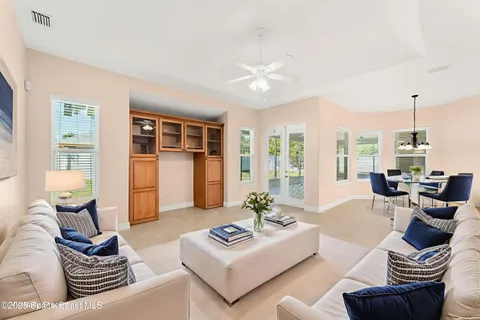 a living room with furniture ceiling fan and a window