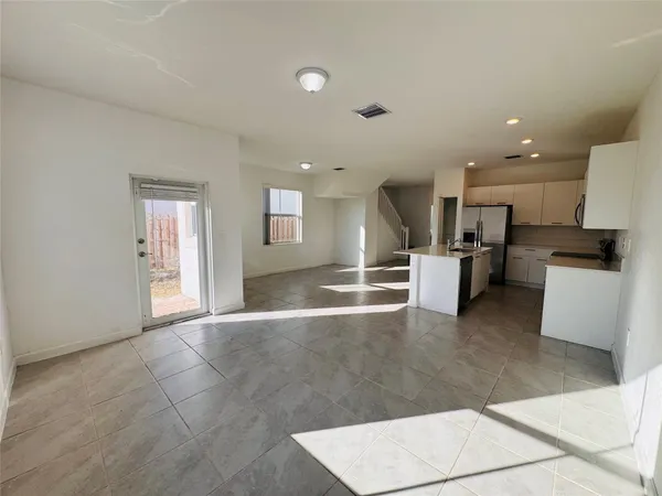 a view of kitchen with stainless steel appliances granite countertop a refrigerator and a sink
