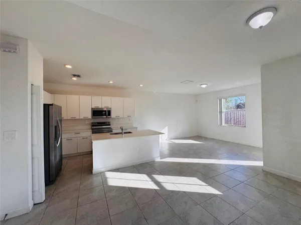 a kitchen with a refrigerator and a stove top oven