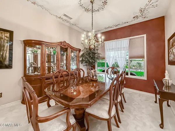 a dining room with furniture a flat screen tv and a large window
