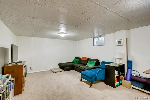 a living room with furniture and a gym machine