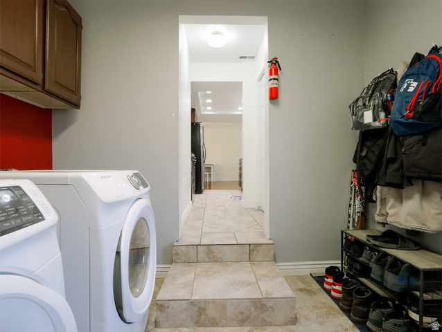 270 East 100 North Monroe, UT 84754 - Photo 22 of 65 Laundry area featuring ceramic tile flooring, upper wood cabinetry, and a vibrant red accent wall