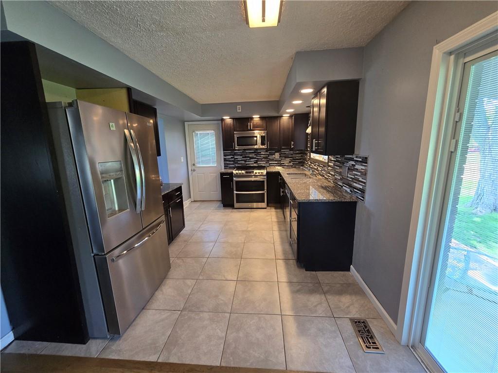740 South Keel Ridge Road Hermitage, PA 16148 - Photo 5 of 33 a kitchen with granite countertop a refrigerator and a stove