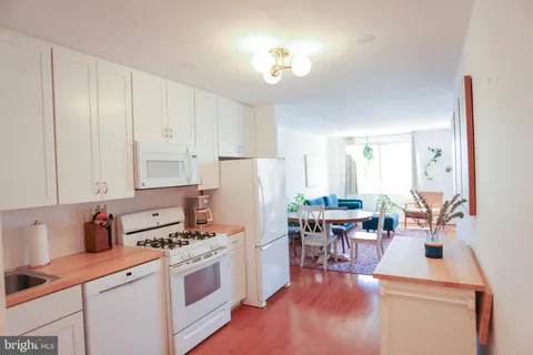 a kitchen with white cabinets and sink
