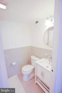 a bathroom with a sink mirror and toilet