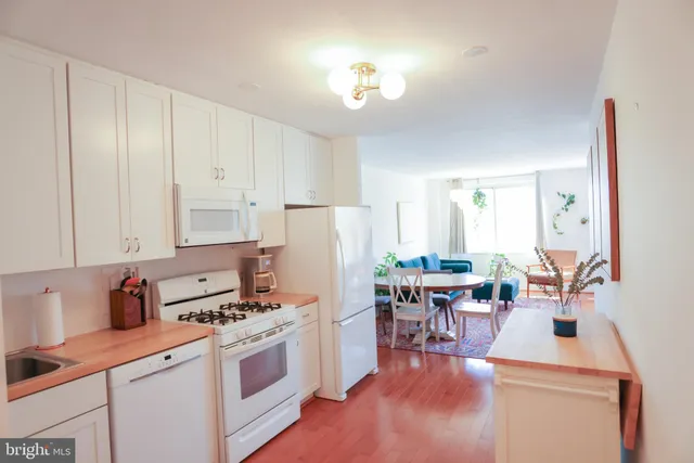 a kitchen with white cabinets and sink