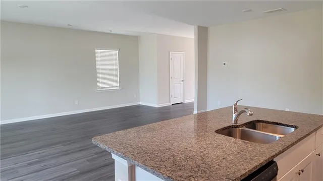 a kitchen with granite countertop a sink and wooden floor