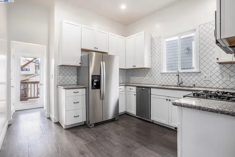a kitchen with stainless steel appliances granite countertop a refrigerator stove and sink
