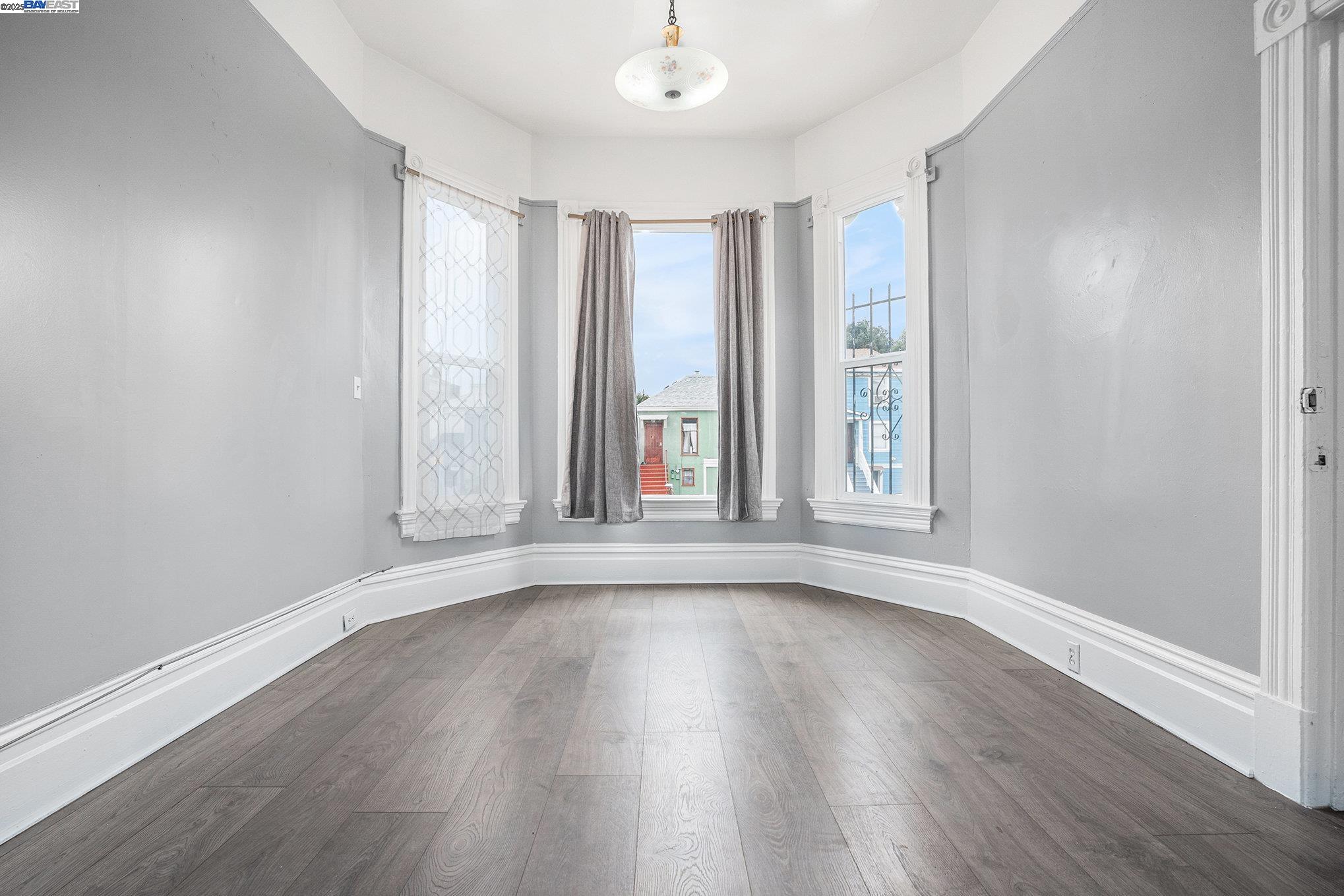 185 7th Street Oakland, CA 94607 - Photo 5 of 20 a view of an empty room with wooden floor and a window