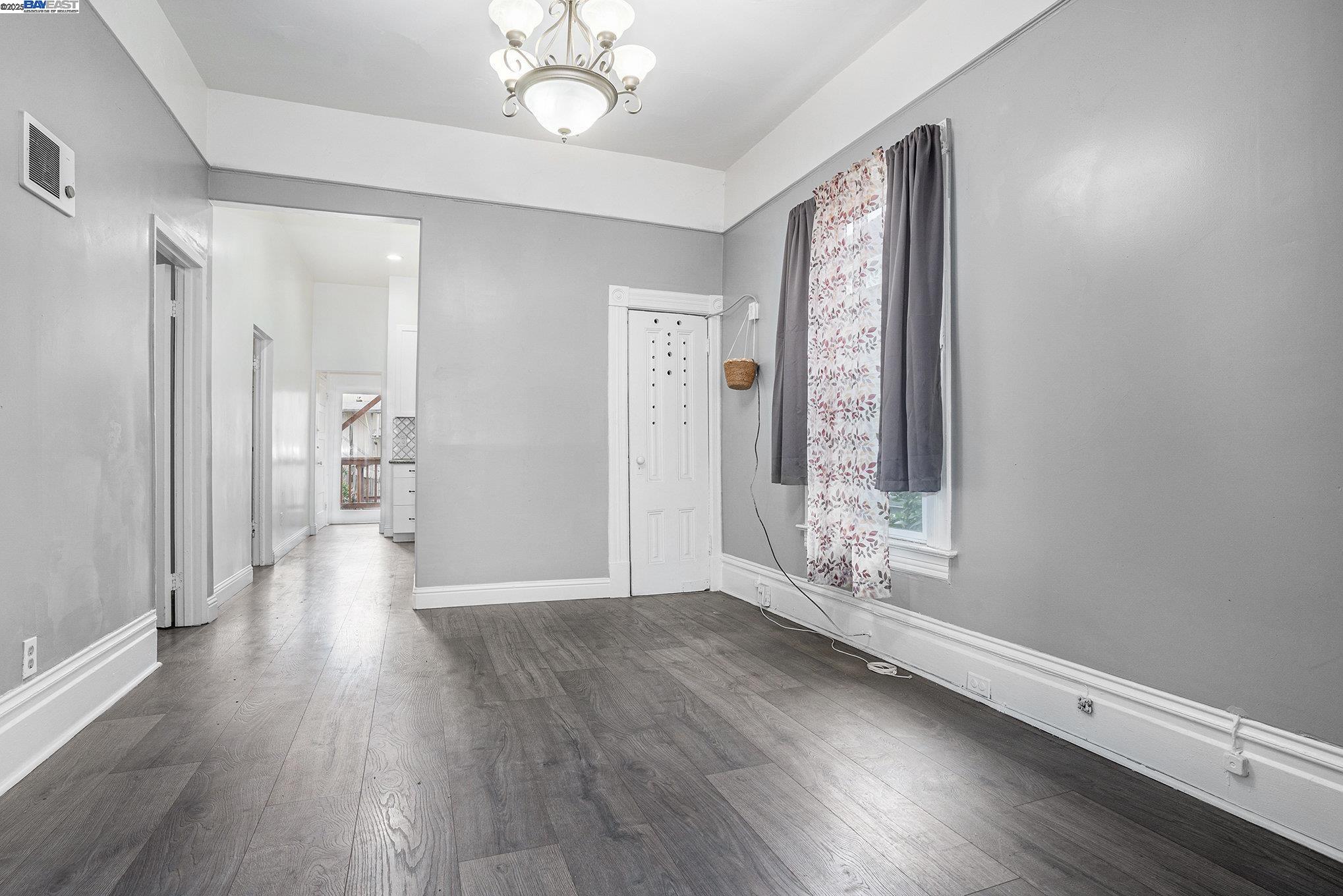 185 7th Street Oakland, CA 94607 - Photo 9 of 20 a view of an empty room with wooden floor and a window
