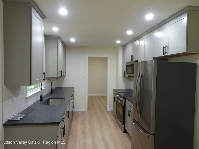 a kitchen with stainless steel appliances granite countertop a refrigerator and a sink