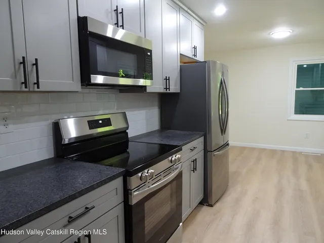 a kitchen with stainless steel appliances granite countertop a stove a refrigerator and a microwave