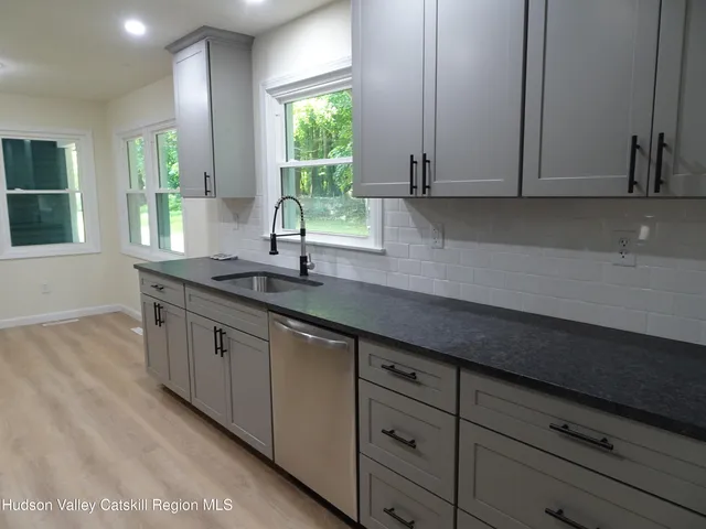 a kitchen with granite countertop white cabinets and window